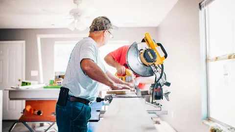 homeowner using power tools for outdoor home improvement and lawn sprinkler repair
