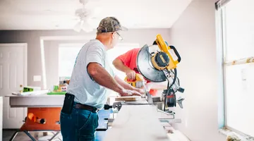 homeowner using power tools for outdoor home improvement and lawn sprinkler repair