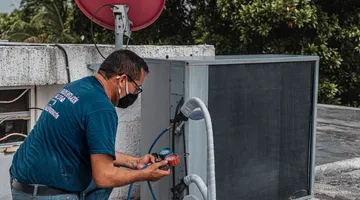 Service gauges and white PVC drain piping at an indoor AC condensate drain line