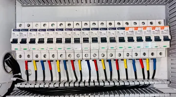 Home electrical panel showing rows of circuit breakers, diagnosing a circuit breaker that keeps tripping