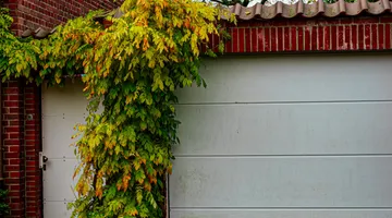 Closed garage door from inside with daylight gap along side frame, how to seal gaps