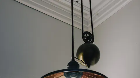Lit pendant ceiling light fixture in a home interior with flickering lights