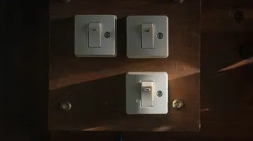 Three white toggle wall switches on plates, how to replace a light switch