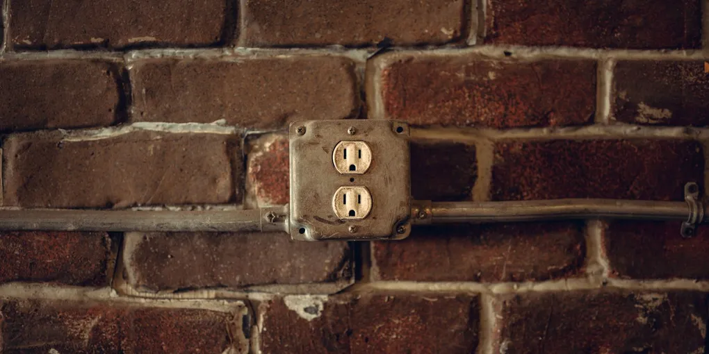 Outdoor outlet receptacle in a metal box on a brick exterior wall that stopped working