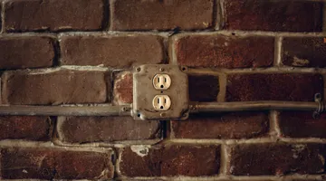 Outdoor outlet receptacle in a metal box on a brick exterior wall that stopped working
