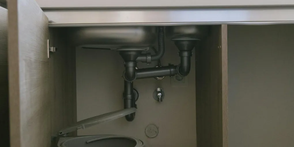Sink drain P-trap and pipes under a cabinet, gurgling sink vent stack diagnostic