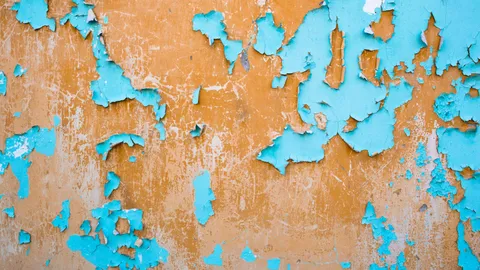 Old peeling and cracked paint exposing the wall underneath, fixing paint peeling off a wall