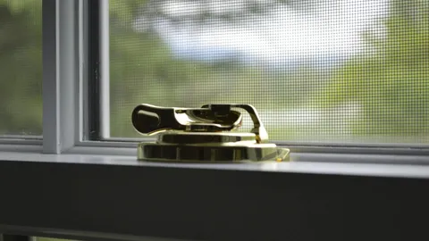 Person cleaning a dirty window screen by hand, cleaning window screens without damaging them