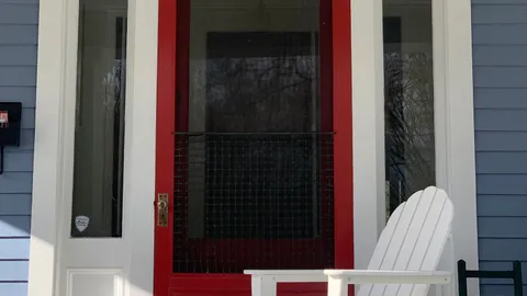 Red mesh screen door on a home entrance, fixing a sticky sliding screen door that drags