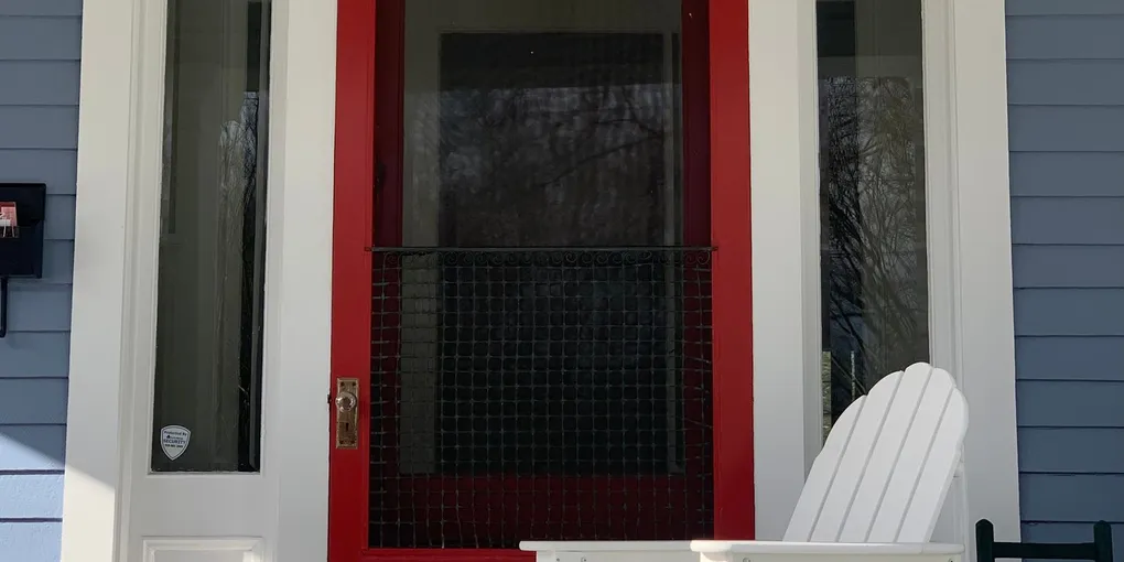 Red mesh screen door on a home entrance, fixing a sticky sliding screen door that drags