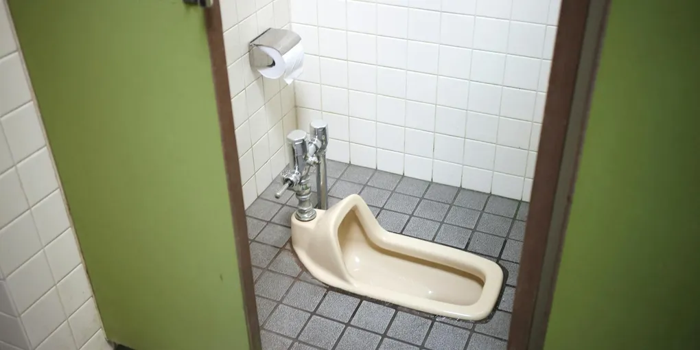 White toilet base with caulk line on bathroom floor, how to fix a wobbly toilet